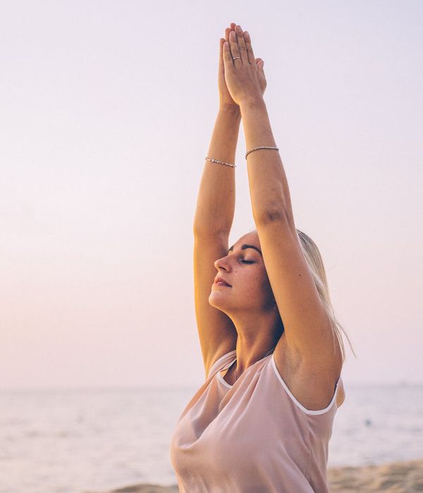 Person stretching outdoors at sunrise, symbolizing energy and mental clarity.